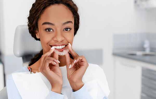 A woman about to wear an Invisalign aligner - Invisalign provider in San Diego