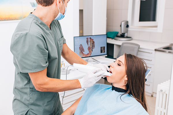 Invisalign - dentist scanning teeth using computer