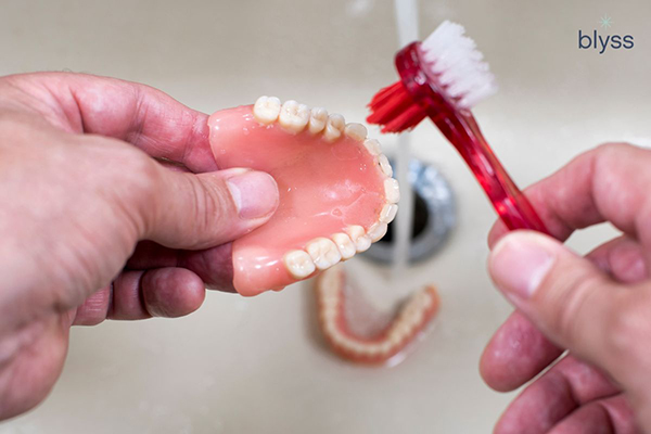 dentures being brushed on the sink