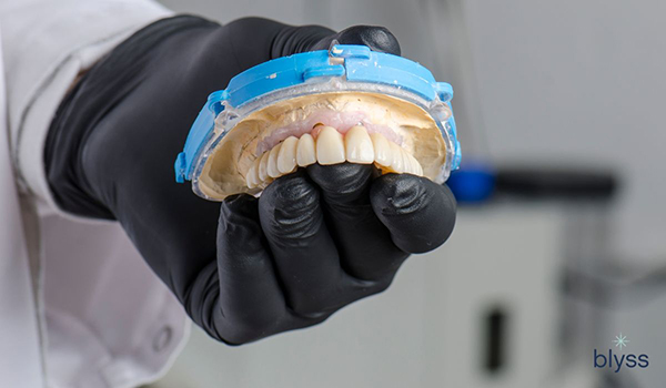 dentist holding zirconia dentures