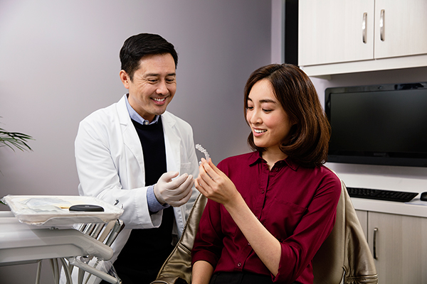 dentist showing aligners to patient