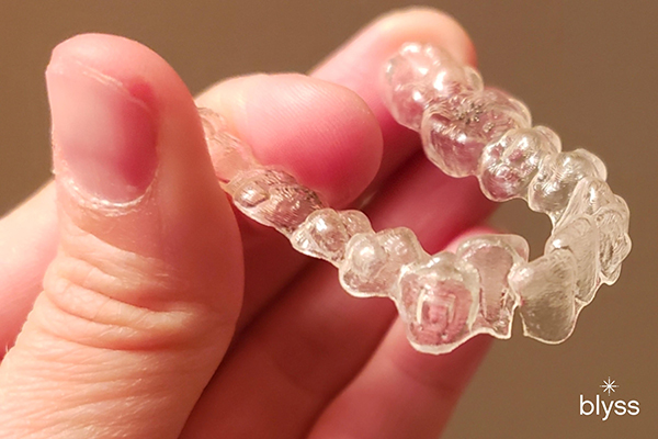 hand holding an invisalign tray with crack