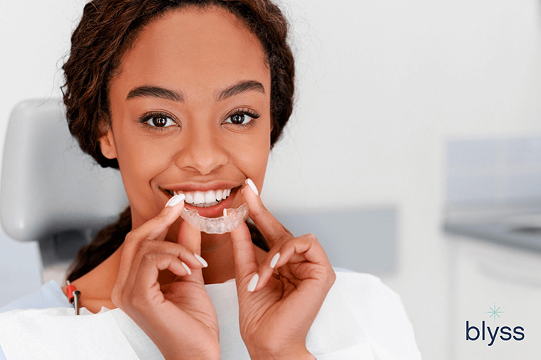 young woman holding Invisalign clear aligners