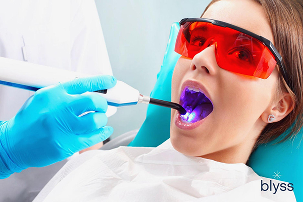 female patient getting laser teeth whitening in a dental office