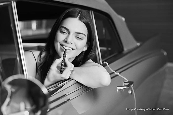 female model Kendall Jenner holding whitening pen inside a car