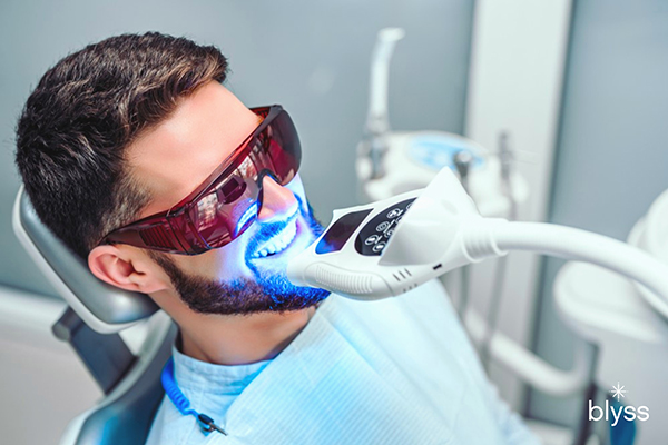 male patient getting laser teeth whitening in a dental office